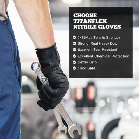 Front view of a forearm wearing black nitrile disposable gloves gripping wrenches in a workshop