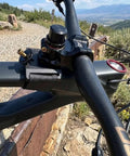 Hands Free Bar Stem Dock For Bike Repair With Foam Pad And Strap shown securing handlebars on mountain terrain