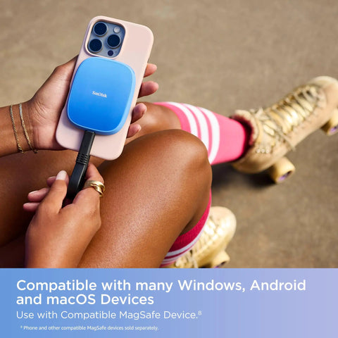 2TB Creator Phone SSD attached to iPhone via MagSafe, in use by person with roller skates, showing mobile setup outdoors