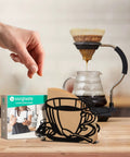 Durable Coffee Filter Holder And Paper Storage Rack With Cup Shaped Stand For Fan Shaped T Shaped And Square Paper Filters Must Have For Home Kitchen Restaurant Picnic Or Wedding Accessory on a wooden counter next to a drip coffee setup.