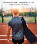 Man carrying Backstop Net 20 Feet By 10 Feet For Lacrosse And Soccer Backyard Sports Barrier Netting with carry bag on sports field