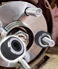 Close-up of Wheel Stud Installer Tool for Most Cars and Light Duty Trucks next to lug bolts on a vehicle hub.