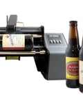 Hustle Ready Semi Automatic Label Applicator For Cylindrical Bottles Cans Jars And Tubes With No Sweat Setup and Smooth Operation Up to 1200 Per Hour For Production Lines in action with beer bottles.