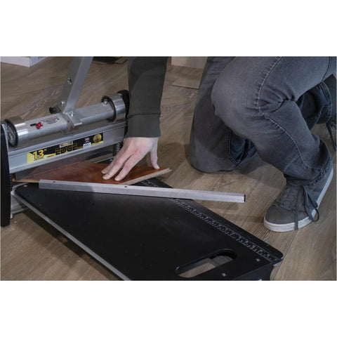 User operating the 13 Inch Heavy Duty Lvp Flooring Cutter With Built In Led Light And Reinforced Steel Table for precise cutting.
