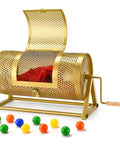 Gold perforated metal raffle drum (15x7) with wooden crank on tripod, red tickets inside.