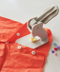Tabletop Snap Button Pliers Kit For 9mm, 11.5mm, 12.5mm And 13mm Plastic No Sew Snaps Press Fasteners For Sewing, Clothing, And Crafting Portable Lightweight DIY Tool in use on orange fabric