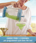 Kitchen device: Margaritaville Key West Frozen Maker with blue lid pouring lime-green margarita into salt-rimmed glass.