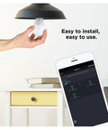 Person installing Zigbee A19 Daylight LED Light Bulb, 8 Pack, 60W Equivalent, Hub Required, shown with smart device control app.