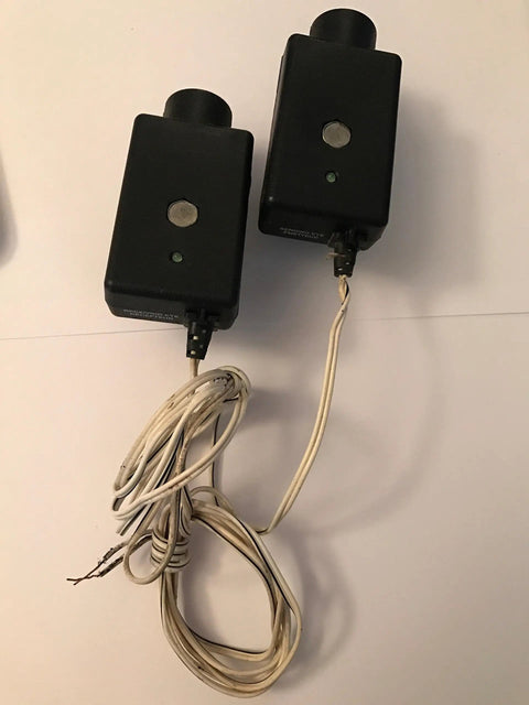 41A4373A Safety Sensors For Garage Door Openers that play nice with LiftMaster and Chamberlain units, black casing with wires shown