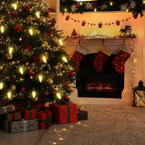 Christmas living room with tree and fireplace, showcasing decorations and stockings.