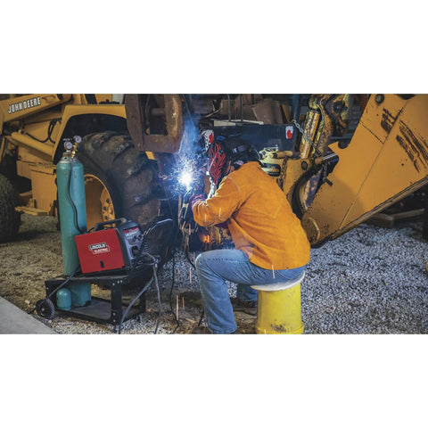 Welder wearing KH807XL Brown Flame Resistant Heavy Duty Leather Welding Jacket working under machinery