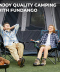 Two adults relaxing in oversized camping chairs for adults with padded seat and back in front of a tent.