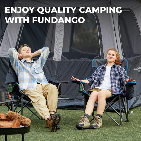 Two adults relaxing in oversized camping chairs for adults with padded seat and back in front of a tent.