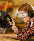 Woman wearing oversized safety goggles that fit over glasses for lab work, chemistry and DIY projects, anti fog, clear PC lens.