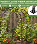 7.2 Ft Outdoor Steel Garden Arch Arbor With Stakes, supporting climbing plants, wide black metal archway in a garden.