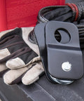 8000 Lb Snatch Block For Off Road Winch Systems That Doubles Pull Power And Eases Angled Pulls Reduces Winch Heat And Gear Stress Fits Up To Five Sixteenth Inch Wire Rope Heavy Duty Black Powder Coated Brackets; black snatch block with winch rope and gloves