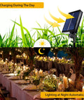 Two Pack 300 LED Solar Fairy Lights 108 Feet Outdoor Indoor Waterproof Twinkle String at garden event, solar panel shown.