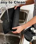 Versatile Silicone Grill Mat For Side Shelves And Counters Fits Blackstone Weber Traeger Pit Boss Flat Top Grills And Smokers Keeps Counters Clean And Organized being cleaned under running water in a kitchen sink, showcasing easy maintenance and flexible material.
