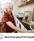 Woman placing photo on shelf with Refillable Ink Tank All-In-One Printer With Wireless, Scanner And Copier in the background