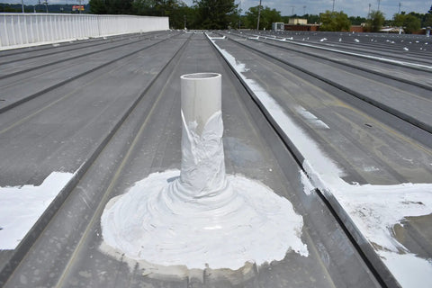 Pipe on roof sealed with Heavy Duty Hundred Percent Silicone Patch Coating For Waterproofing Those Tough To Reach Spots On Roofs Gutters And Walls Easy Application With Brush Or Putty Knife One Gallon Translucent.