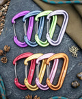 Colorful Built Tough Ultra Strong 12kN Carabiner Clips 3.2 Inch Aluminum Carbineers for hiking on slate background