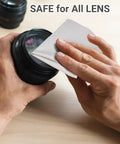 Close-up of hands wiping a lens with a light gray microfiber glasses cleaning cloth
