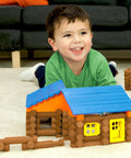 Child playing with Oak Creek Lodge Wooden Building Set With 137 Real Maple Logs, Retro Construction Fun For Kids 3 Plus