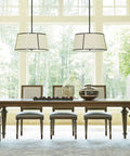 Bright dining room with wooden table and chairs under modern light fixtures