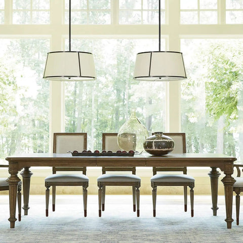 Bright dining room with wooden table and chairs under modern light fixtures