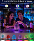 Couple enjoying Night Light Bluetooth Speaker with 3D Glass Fireworks Lamp on table, showcasing colorful LED lighting.