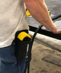Hella Strong Mini Adjustable Welding Magnet With Slick On Off Rotating Base And 150 Lb Hold Power For Multi Angle Metal Fabrication secured in a holster on a worker's waist.