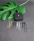 Hassle Free Snap In Dial Quartz Clock Movement Kit With Sleek Straight Hands includes a black movement and various clock hands.