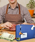 Man using tape sealer with 300 Count Ground Pork Freezer Bags 1Lb Ground Meat Bags for packaging meat on a kitchen table.