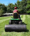 Person towing Tow Behind Poly Lawn Roller With Easy Turn Plug For Quick Fill And Dump 485 Lb Capacity 18 By 48 Inch Drum on large lawn