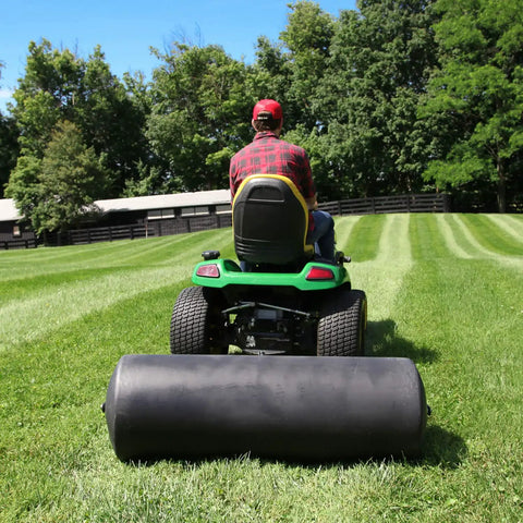 Person towing Tow Behind Poly Lawn Roller With Easy Turn Plug For Quick Fill And Dump 485 Lb Capacity 18 By 48 Inch Drum on large lawn