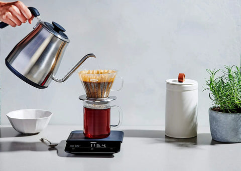 Gooseneck Electric Kettle For Pour Over Coffee And Tea With Dialed In Temperature In One Degree Increments From 104 To 212 Fahrenheit And 40 To 100 Celsius Built In Brew Timer Stainless Steel 1 Liter pouring water into coffee dripper on scale