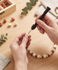 Person using Hardcore Micro Drill Bit Set With Slick Black Pin Vise to work on wooden beads and craft projects.