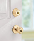 Polished brass Keyed Entry Knob and Single Cylinder Deadbolt Combo for Exterior Doors, installed on white door.