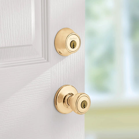 Polished brass Keyed Entry Knob and Single Cylinder Deadbolt Combo for Exterior Doors, installed on white door.