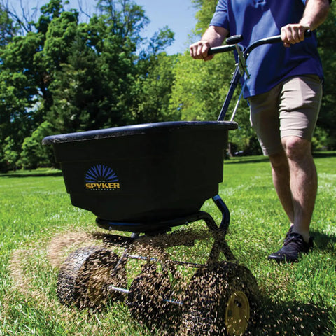Spyker Pro Series 50 Pound Broadcast Spreader With 5 Pound Handheld Spreader Kit in use on lawn by man