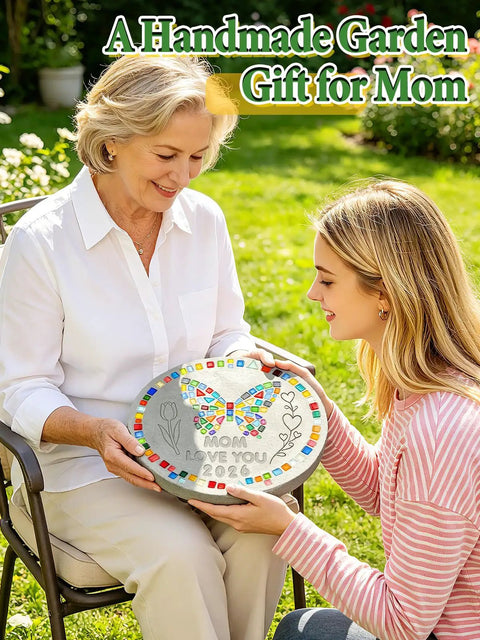 Two women holding a decorated stepping stone with colorful mosaic tiles and butterfly design, suitable for garden pathway.
