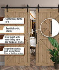 Two Pack 12 Inch Diamond Tapered Barn Door Handles Black Cast Iron Pulls installed on wooden sliding doors indoors.
