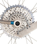 All In One Chain Whip And Pedal Wrench For Bike Maintenance, 10.75 Inch Steel Tool, shown on bike cassette, silver finish