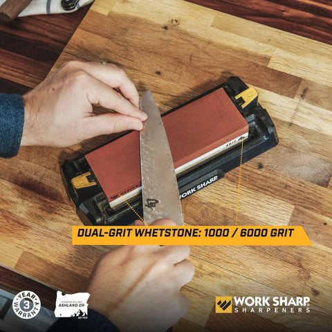 Pro Grade Kickass Benchtop Whetstone Knife Sharpener With 1000/6000 Grit Corundum Stones in use on a wooden table.