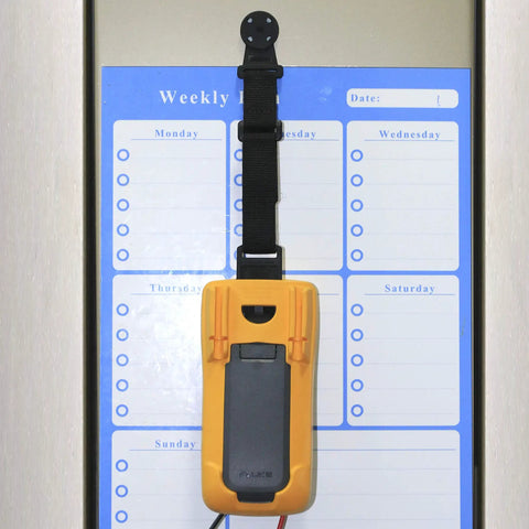 Magnetic Hanger Kit For Fluke Multimeters With Strap And Clip holding tool on a metal surface in front of a weekly planner.