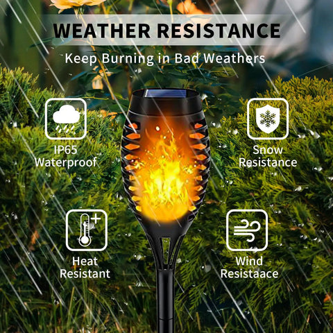 Lit Outdoor Solar Torch Lights Flickering Flame showing weather resistance, illuminating beside green foliage.