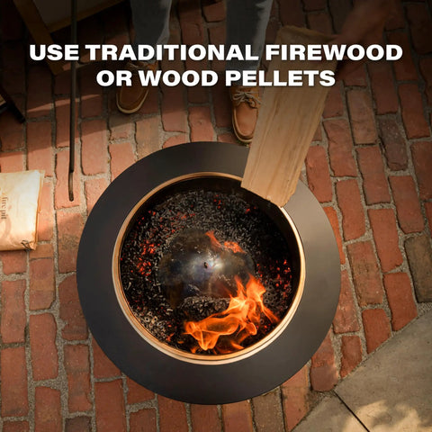 Top view of a Smokeless 25 Inch Wood Burning Outdoor Fire Pit With Removable Ash Pan on a brick patio with wood being added.