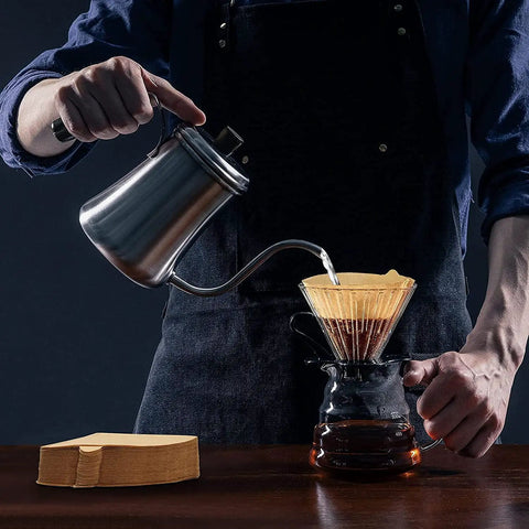 Person pouring water over coffee grounds with Two Cone Coffee Filters For Pour Over V60 Dripper And Drip Coffee Maker 1 To 4 Cup 100 Count Natural Unbleached Disposable Size 02 No Mess Easy Cleanup Biodegradable No Bleach Smooth Clean Brew Every Time
