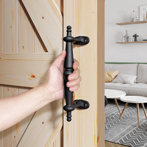 9 Inch Barn Door Pull Handle Set In Rustic Black Aluminum with ergonomic chamfered edges being held on a wooden door.