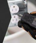 GFCI Receptacle Tester With Push Button For Fast And Accurate Wiring Checks, compact design, held by gloved hand near outlet